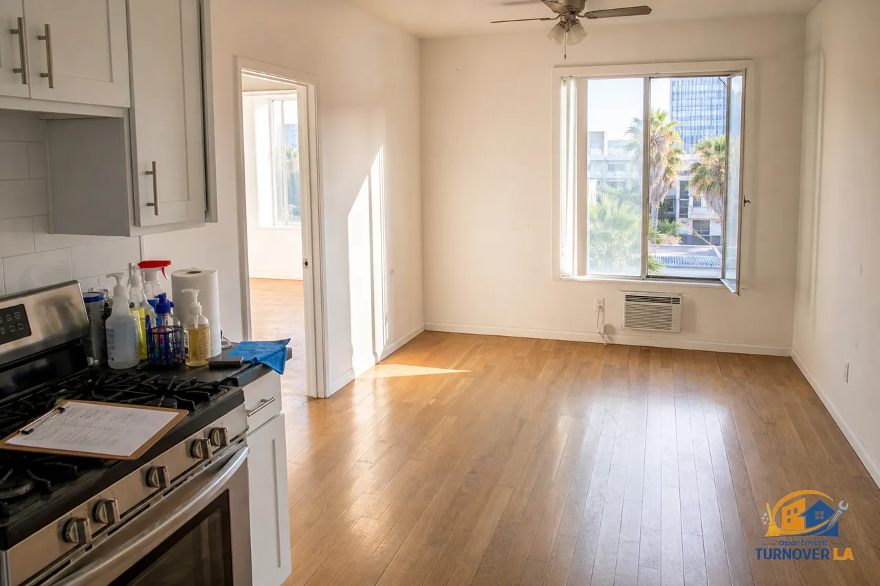 LA one-bedroom during turnover with a printed checklist on a clipboard, cleaning kit staged on the kitchen counter, and palm-lined Koreatown view